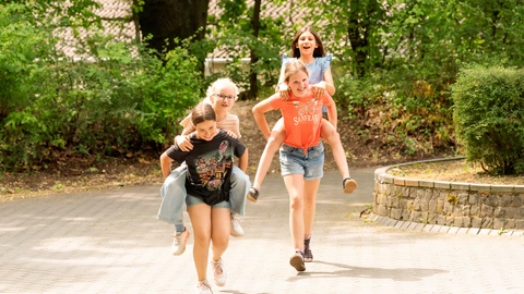Kinder spielen fröhlich auf dem Pausenhof des CJD und genießen ihre Zeit in der Schule.