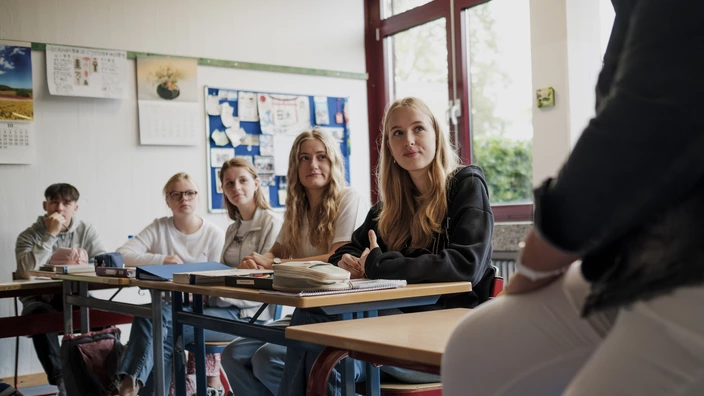 Schüler sitzen konzentriert im Klassenraum und arbeiten engagiert an ihren Aufgaben.