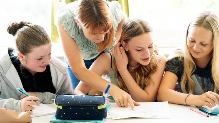 Schüler sind aufmerksam im Klassenraum und beschäftigen sich aktiv mit ihren Lerninhalten.