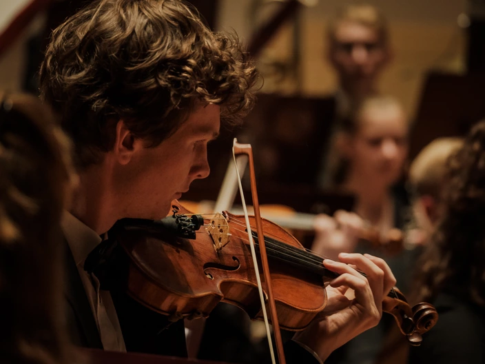 Ein Junge spielt leidenschaftlich Geige und bringt seine musikalischen Fähigkeiten zum Ausdruck.