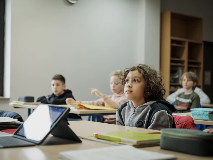 Eine Klasse im Unterricht. Aufmerksam nach vorne schauend.